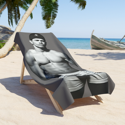 A black and white fashion photograph of Marky Mark wearing a black Calvin Klein cap and white Calvin Klein briefs on a premium beach towel on a lounge chair by The Pink Rocket New Orleans a fay owned gift shop.