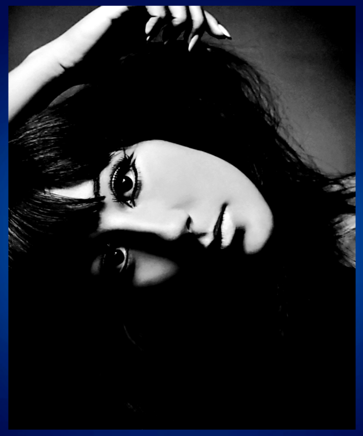 Black and white close-up portrait of Cher with dramatic shadowing, dark hair, and a hand near her head. Sold in The Pink Rocket New Orleans gay gift shop