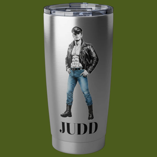 A brushed stainless steel tumbler with a clear lid, featuring a graphic of a muscular Tom of Finland man in a black leather jacket and blue jeans, peraonalized. with the name Judd For sale in The Pink Roket New Orleans gay gift shop.