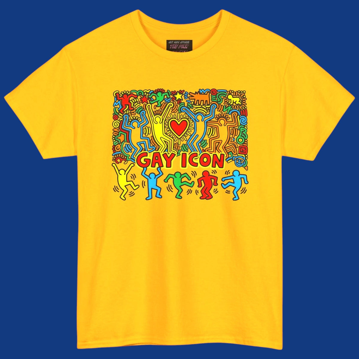 An yellow short-sleeve crewneck t-shirt featuring a colorful graphic of a Keith Haring style 'Gay Icon' graphic, with a red heart and the words 'GAY ICON' in red, displayed against a solid blue background. Sold in The Pink Rocket New Orleans gay gift shop.