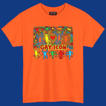 An orange short-sleeve crewneck t-shirt featuring a colorful graphic of a Keith Haring style 'Gay Icon' graphic, with a red heart and the words 'GAY ICON' in red, displayed against a solid blue background. Sold in The Pink Rocket New Orleans gay gift shop.