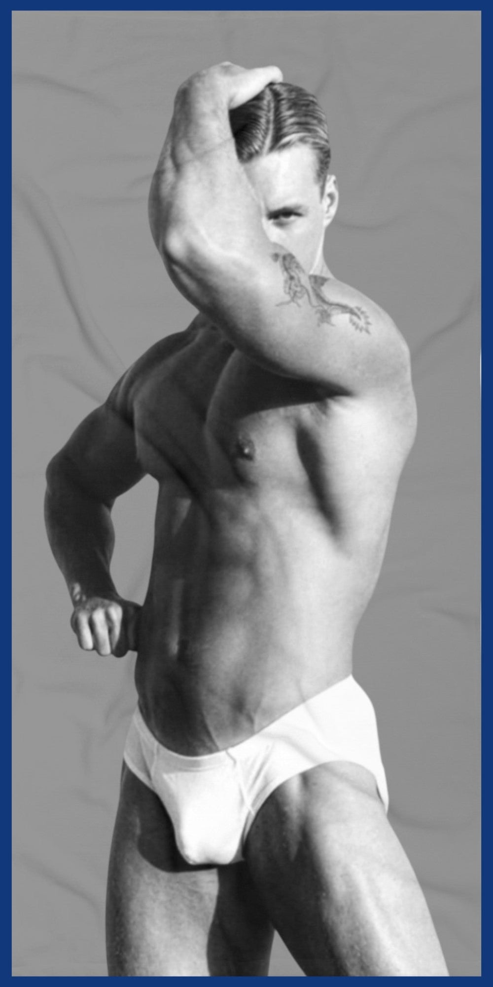A custom  gray and white towel with a black-and-white photo of a hunky gay man in a bathing suit. Sexy and ready for the beach. For sale in The Pink Rocket New Orleans gay owned gift shop.