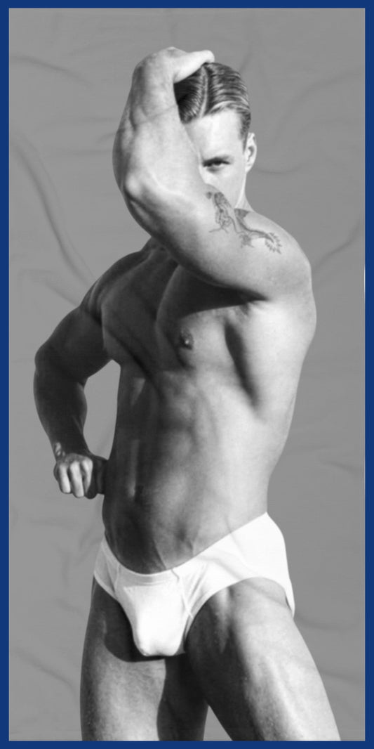 A custom  gray and white towel with a black-and-white photo of a hunky gay man in a bathing suit. Sexy and ready for the beach. For sale in The Pink Rocket New Orleans gay owned gift shop.