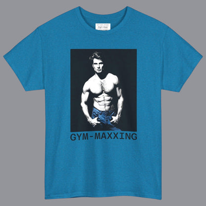A teal blue short-sleeve t-shirt with a graphic print of a gay muscular shirtless man wearing blue pants, with the text 'GYM-MAXXING' printed below the graphic. Designed and for sale in The Pink Rocket New Orleans gay gift shop.