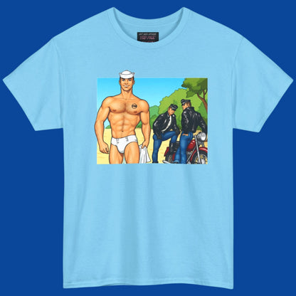 A man wearing a baby blue t-shirt with a graphic print of a hunky muscular man in white briefs, standing outdoors being crusied by sey motercycle men in leather. Designed and sold in The Pink Rocket New Orleans gift shop for gay men.
