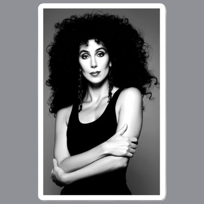 A black and white portrait print of  Cher with voluminous curly hair, wearing a black tank top and dangling earrings, centered within a white border on a gray background. For sale in The Pink Rocket NOLA gay gift shop.
